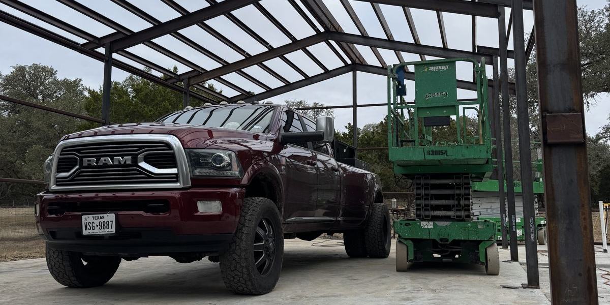 Steel building frame with the Ram and a scissor lift underneath